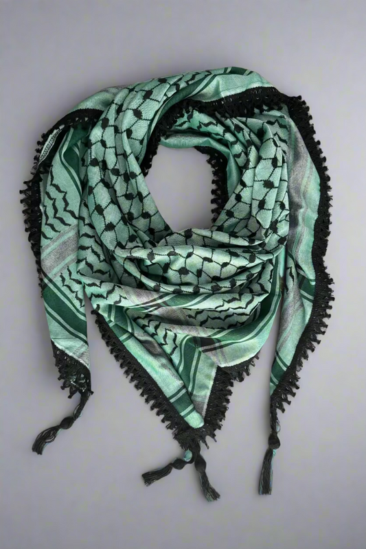 Green patterned scarf with black trim on a wooden surface
