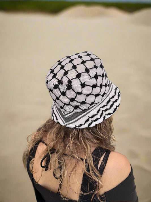 Person wearing a black and white kufiyya bucket hat