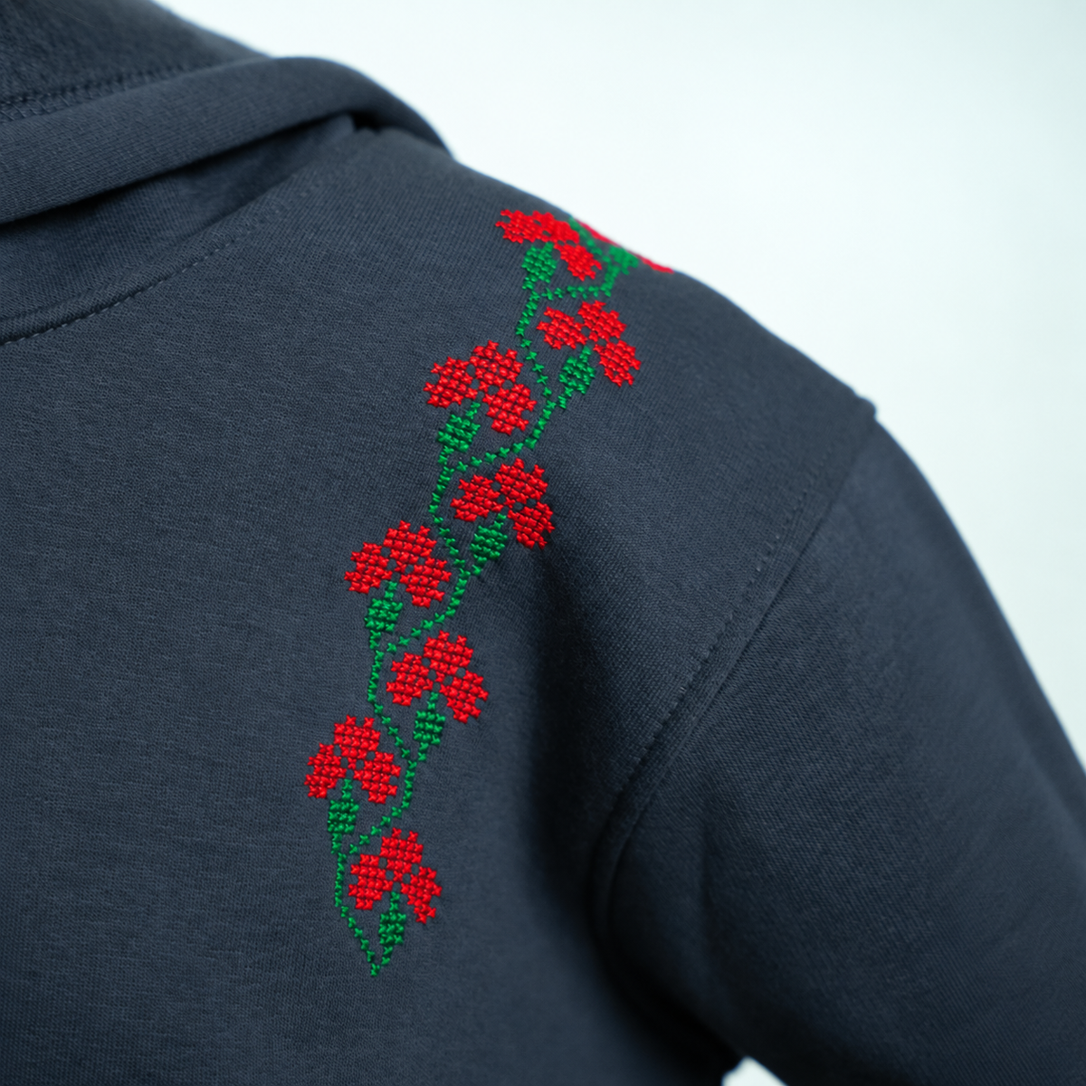 Hand-stitched rose embroidery on the shoulder of the Jouri Hoodie