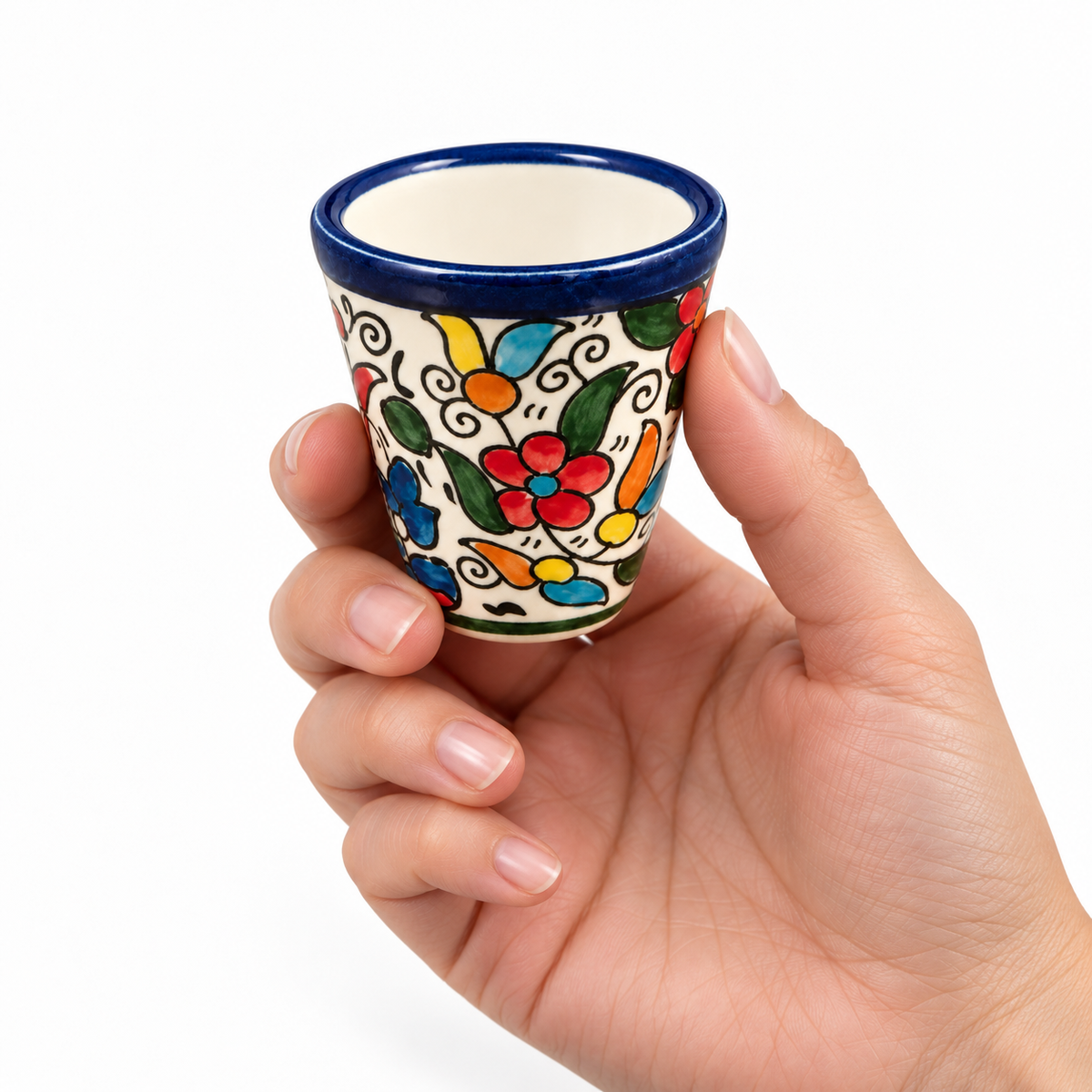 Multicolor Zahra espresso cup held in a model's hand to show its small size